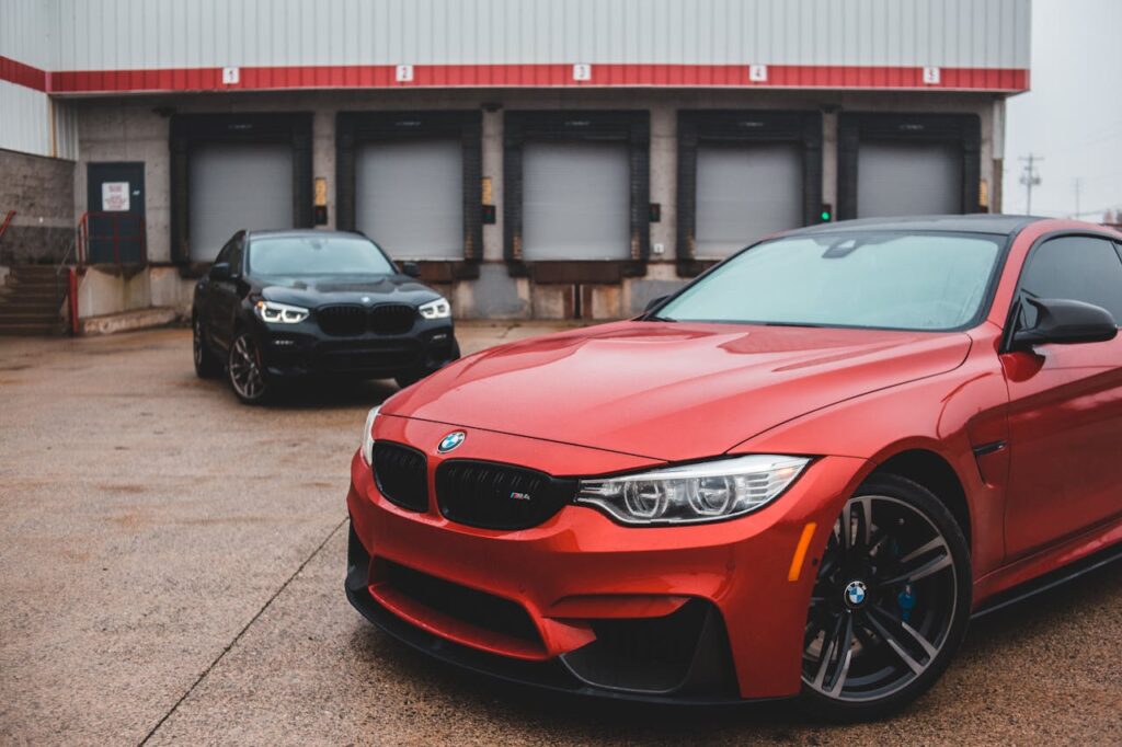 Sports cars with shiny polished bumpers and stylish disks parked near building in overcast day